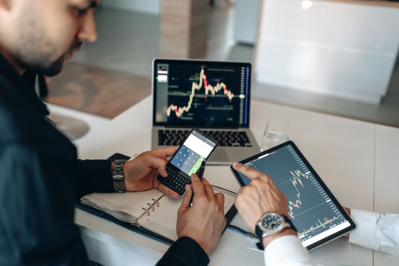 Mastering the First Impression: Your intriguing post title goes here Two professionals examining financial data on digital devices at a modern office.